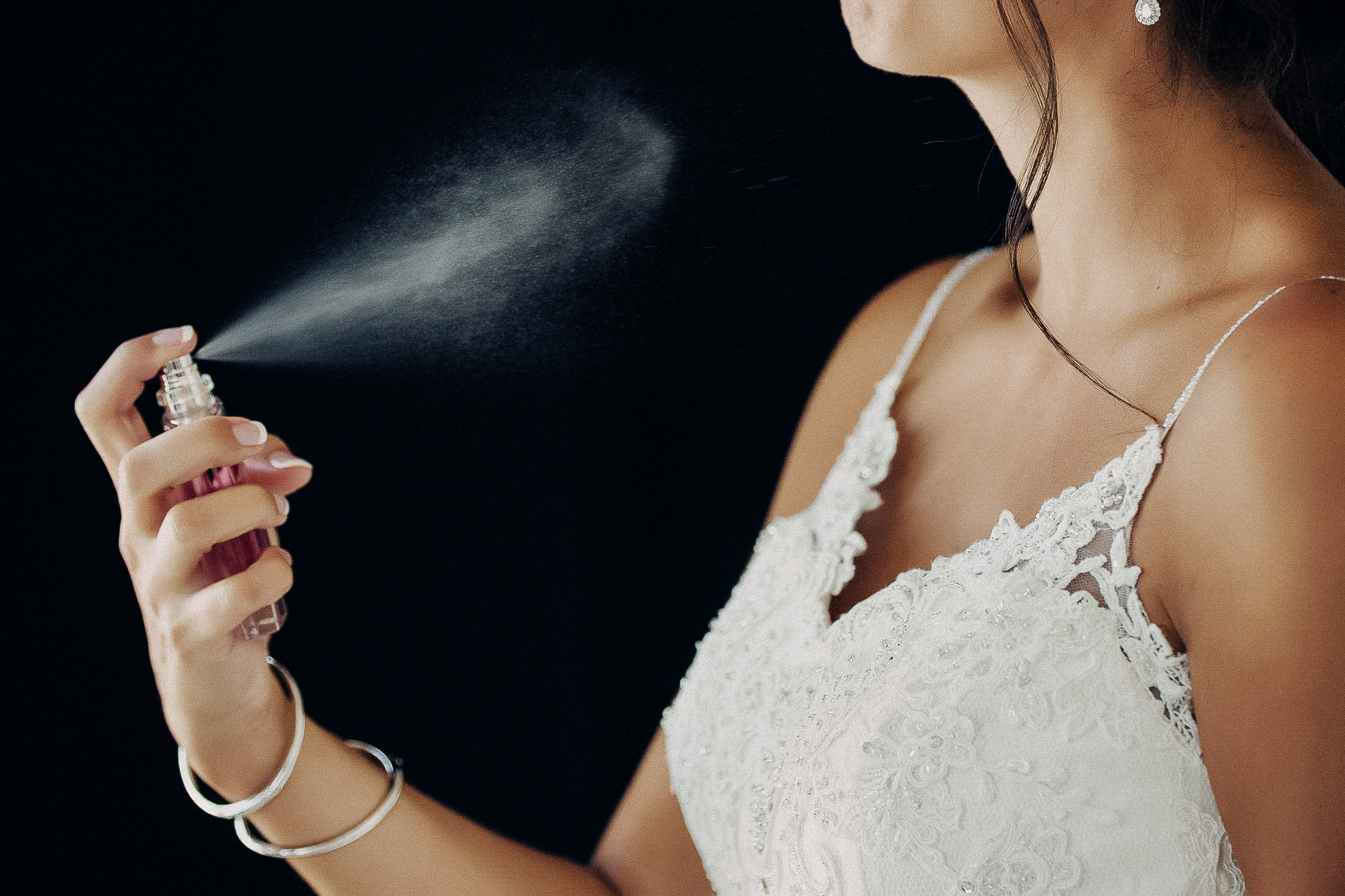 Bride applying perfume before the wedding